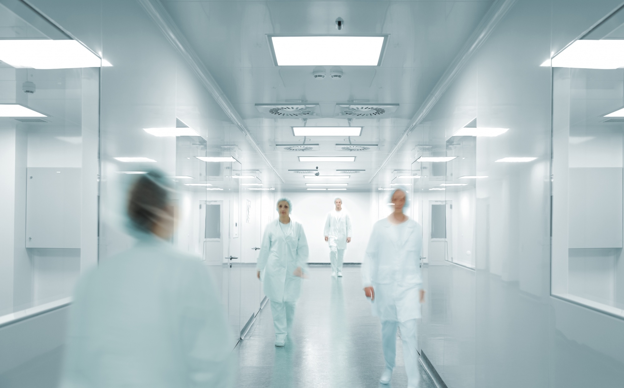 Ezra Mega Case Study 7 Healthcare staff walking through a clean white hospital corridor.